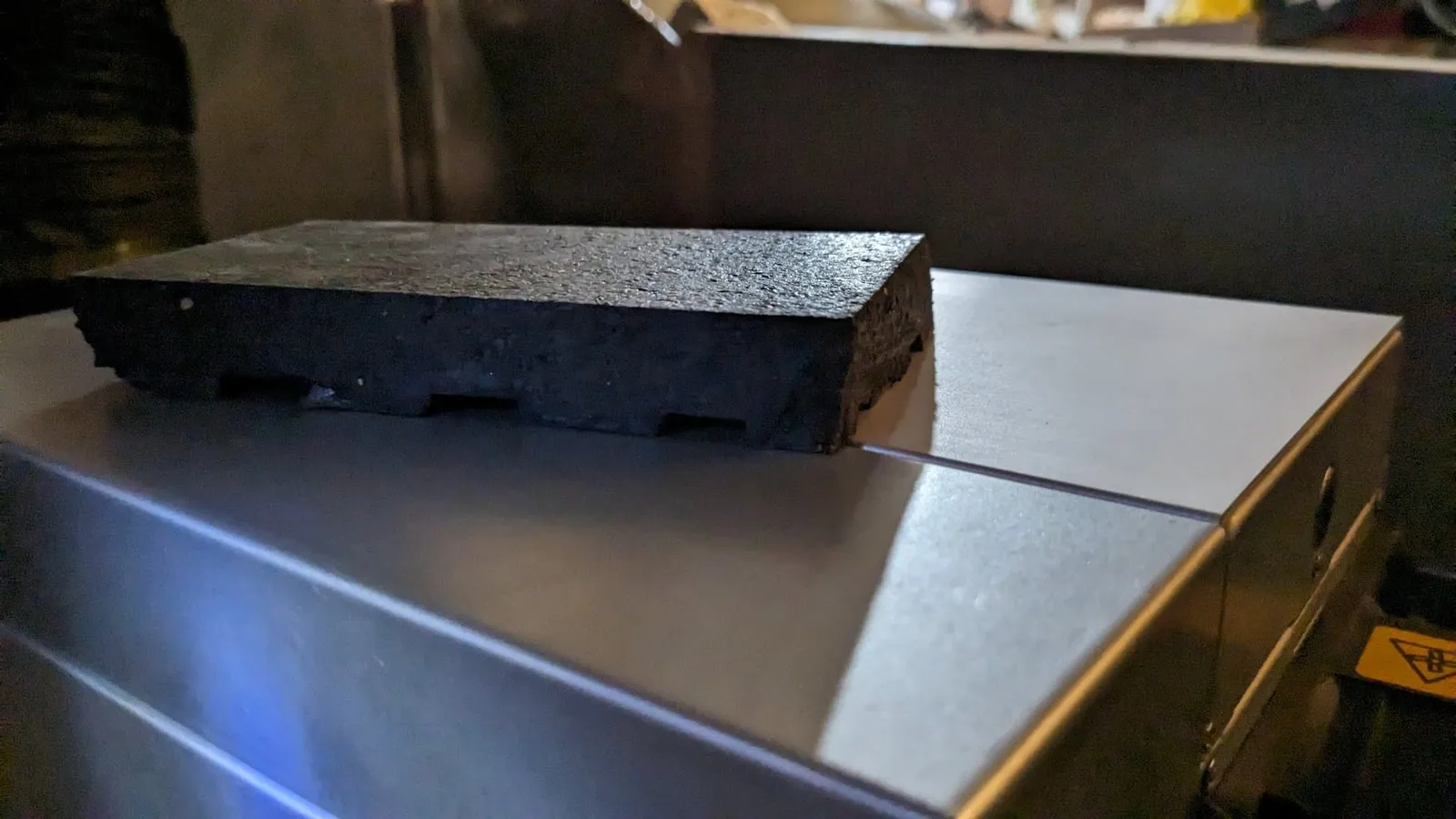 A slab of rubber horse stall mat lying on the miner’s metal case